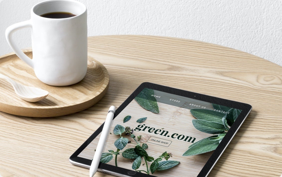 Een kopje koffie naast een tablet waarop de website van een kwekerij te zien is, gemaakt met Jimdo.