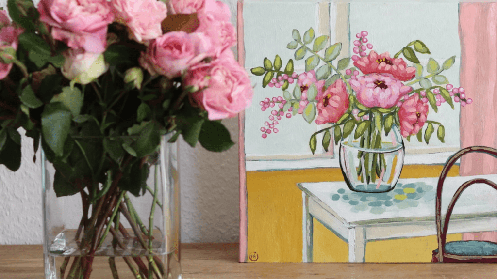 A watercolor painting of flowers next to a flower arrangement