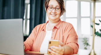 Eine Frau vergleicht den Look ihrer DIY-Website auf Laptop und Smartphone