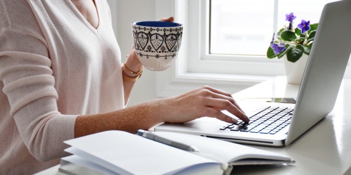 Eine Frau sitzt an ihrem Laptop und baut jede Menge Call-to-Actions auf ihrer Website ein.