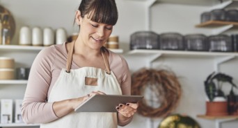 Eine Bäckerin bearbeitet ihre Produktbeschreibungen mithilfe ihres Tablets