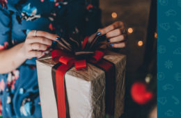 Eine Frau öffnet ein Geschenk. Daneben ein Banner mit # Jimdo Gewinnspiel