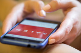 Ein Smartphone auf dessen Bildschirm das Wort Sales zu sehen ist