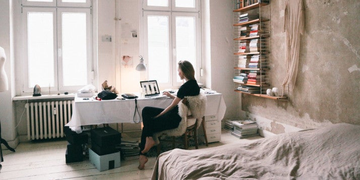 Eine Frau sitzt an ihrem Schreibtisch und arbeitet produktiv von zu Hause aus.