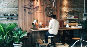 Ein junger Unternehmer sitzt an seinem Werktisch und tüftelt an seinem Produkt.