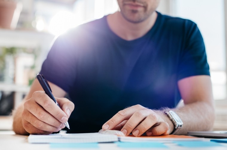 Ein Unternehmer arbeitet an einer Liste mit Einsparungen