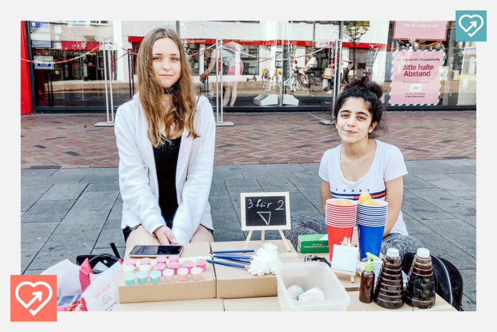 Zahraa und Neele verkaufen ihre ersten Produkte am eigenen Stand in der Fußgängerzone