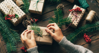 Eine Frau ist gerade dabei, ihre originellen Weihnachtsgeschenke einzupacken.