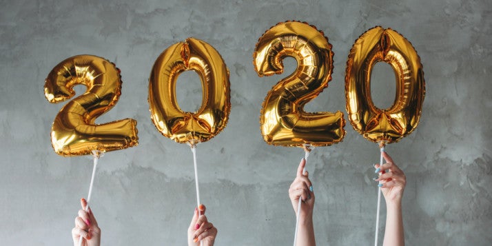 Mehrere goldene Luftballone formen die Zahl 2020