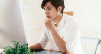 Ein Selbstständiger grübelt vor seinem PC über Webdesign.