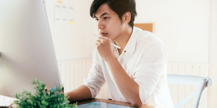 Ein Selbstständiger grübelt vor seinem PC über Webdesign.