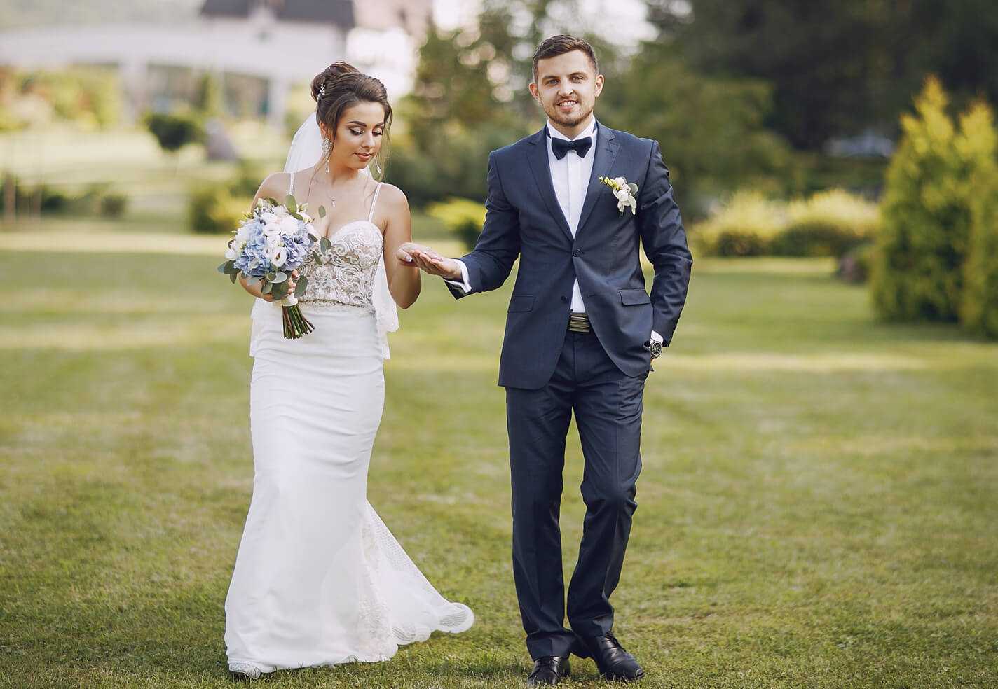 Un marié tient la main de la mariée le jour de leur mariage.