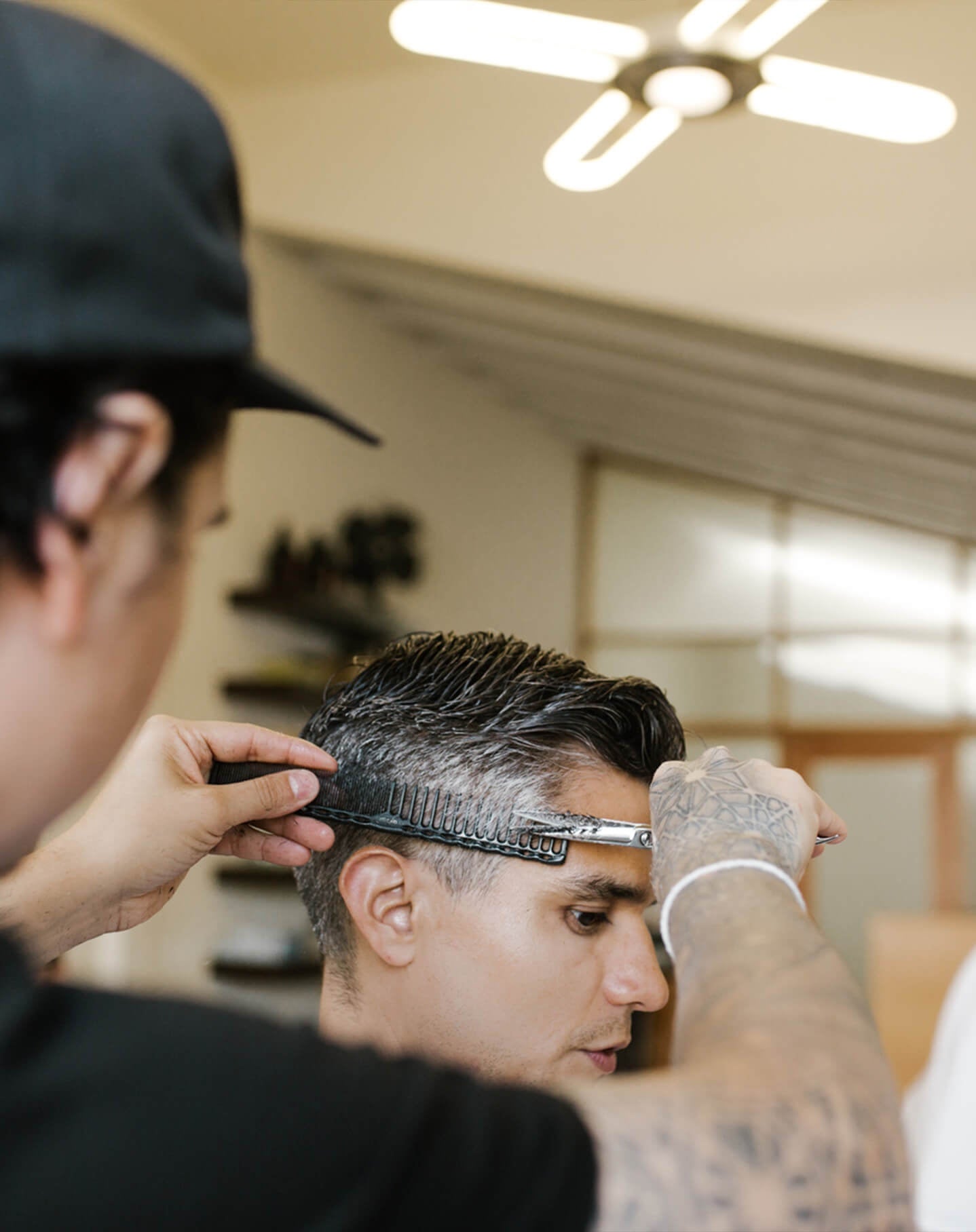 Ein Friseur schneidet die Haare eines Kunden in seinem Friseursalon