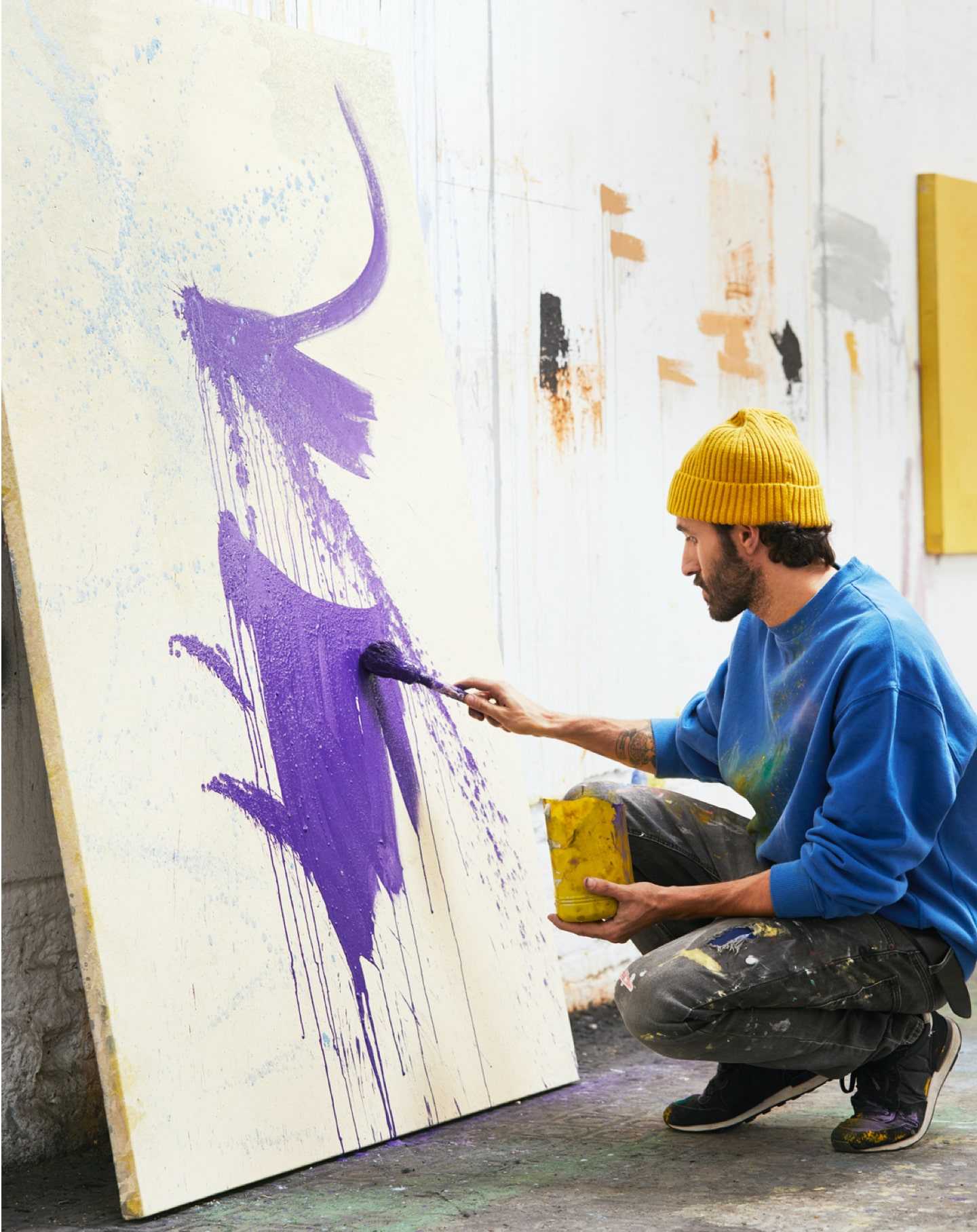 Une artiste dans son studio travaille sur une peinture pour son site de peintre