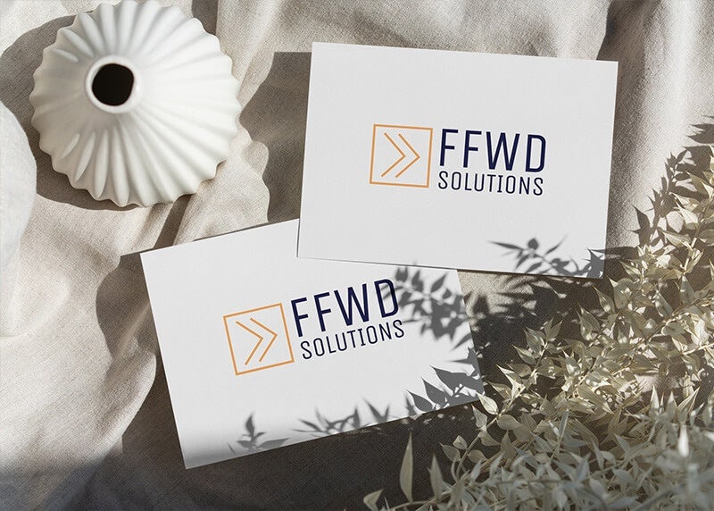 Two white business cards with the FFWD Solutions logo printed on them