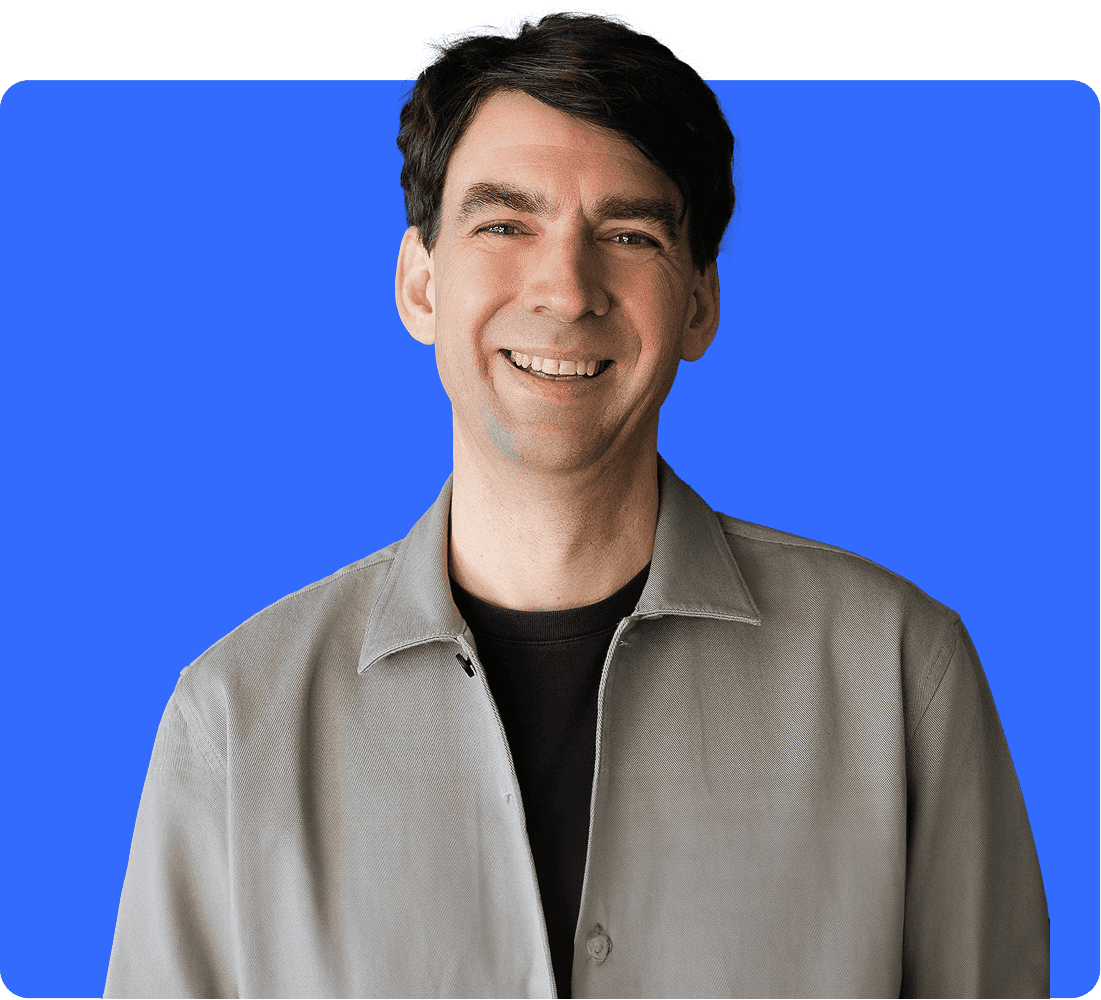 Matthias 'Matze' Henze, CEO and founder of Jimdo, wearing a brown flat cap and light blue shirt, smiling warmly at the camera, against a light purple background.