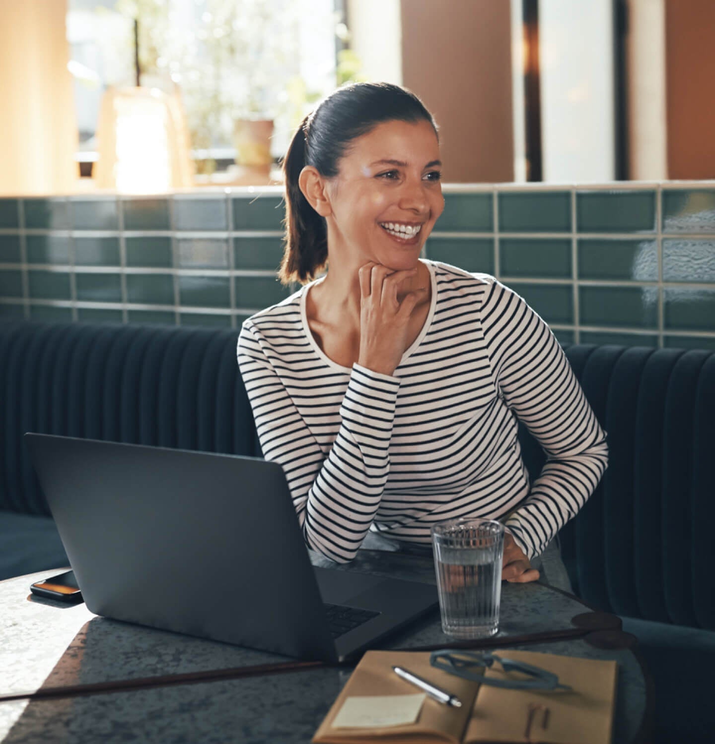Entrepreneur souriant qui boit une tasse de café tout en travaillant sur son site web